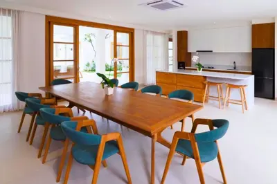 a dining room with a wooden table and chairs at Narasnama 6 BR Private Pool Villa in Canggu