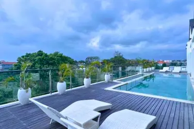 a deck with chairs and a swimming pool on a building at Abimana 5 BR Presidential Suite Private Pool in Jimbaran