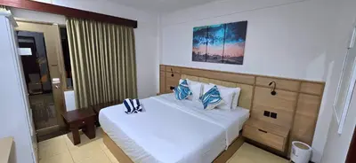 a bedroom with a large white bed with blue pillows at C&C Jayakarta Residence Apartment Legian Kuta Bali in Seminyak