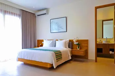 a bedroom with a large bed and a bathroom at Nawasena 5 BR Private Pool Villa in Canggu
