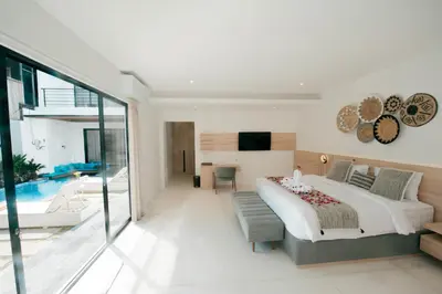 a bedroom with a large bed and a living room at Seminyak Villa Luxury 4BR near Beach Lafavela in Seminyak
