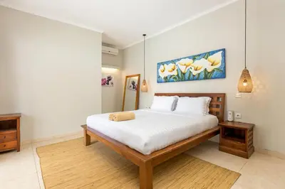 a bedroom with a large bed with white sheets at Villa Raja Seminyak by KING in Seminyak
