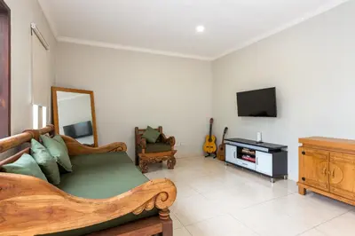 a living room with a bed and a television at Villa Raja Seminyak by KING in Seminyak