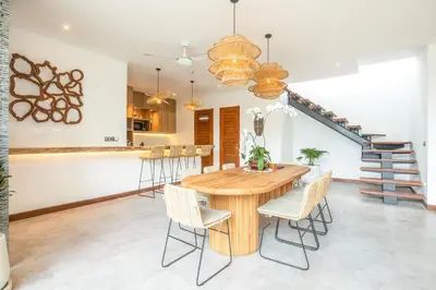 a kitchen and dining room with a wooden table and chairs at Coastal Elegance 4BR Villa, 400m to Finns in Canggu