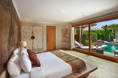 a bedroom with a large bed and a swimming pool at Villa Gahana Bali in Seminyak