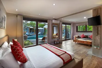 a bedroom with a large bed and a living room at Villa Gahana Bali in Seminyak