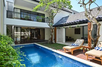 a villa with a swimming pool and a house at The Cabana Villa in Seminyak