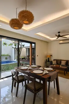 a dining room with a large wooden table and chairs at The Cabana Villa in Seminyak