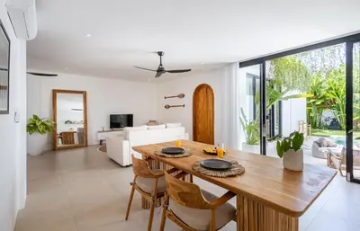 a dining room and living room with a table and chairs at New Villa Manis proche Seminyak in Seminyak