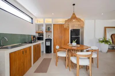 a kitchen with a wooden table and a dining room at New Villa Manis proche Seminyak in Seminyak