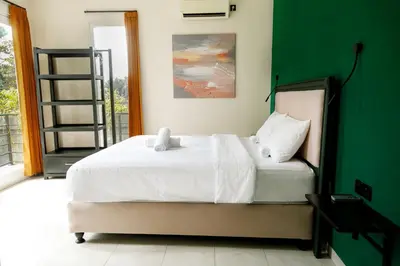 a bedroom with a white bed and a green wall at Villa Majapahit Kuta 5 bedrooms in Legian