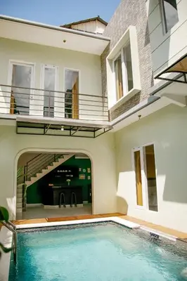 an indoor swimming pool in front of a house at Villa Majapahit Kuta 5 bedrooms in Legian