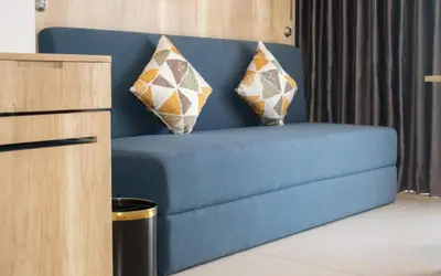 a blue couch with two pillows on it in a room at Anagata Paradiso Bali in Nusa Dua