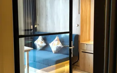 a glass door with a blue couch in a room at Anagata Paradiso Bali in Nusa Dua