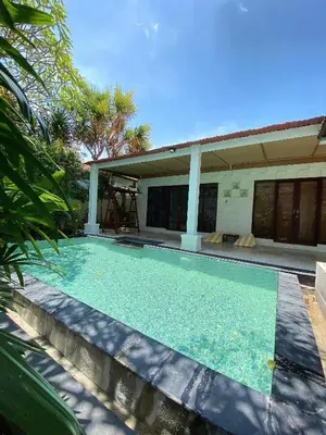 a swimming pool in front of a house at One Bedroom Private Pool Classic Villa in Kuta