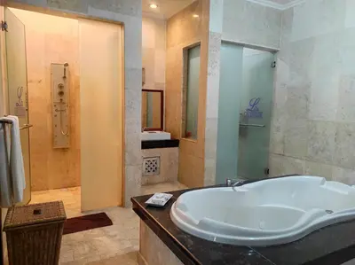 a bathroom with a large tub and a shower at One Bedroom Private Pool Classic Villa in Kuta