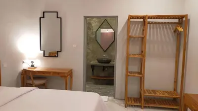 a bedroom with a bed and a mirror and a table at Aleenka House in Canggu