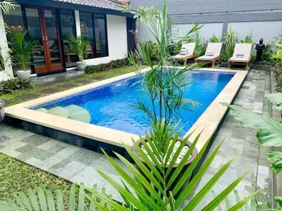 a swimming pool in the middle of a yard at Villa VALARI - Seminyak Legian - 5 Bedrooms in Seminyak