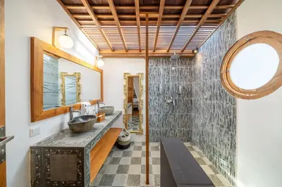 a bathroom with a sink and a mirror at The Secret Jungle Villas Seminyak in Seminyak