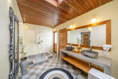 a bathroom with a sink and a large mirror at The Secret Jungle Villas Seminyak in Seminyak
