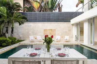 a dining room with a table and a pool at Villa Manis Cantik in Seminyak
