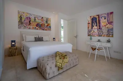 a bedroom with a large white bed and a chair at Villa Manis Cantik in Seminyak