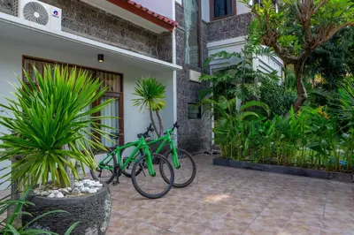 a green bike parked next to a building at Atres Griya Villa 5 Private Bedroom Kuta in Kuta