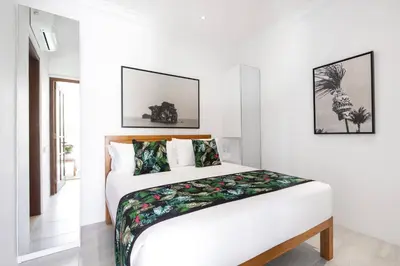 a white bedroom with a bed in a room at Villa Nook in Seminyak