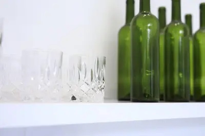 a glass sitting on a shelf next to wine bottles at Villa Nook in Seminyak