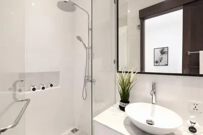 a white bathroom with a sink and a shower at Villa Nook in Seminyak