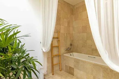 a bathroom with a bath tub and a shower curtain at 2 Bedroom private Pool Seminyak in Seminyak