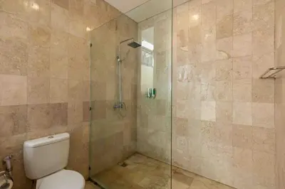 a bathroom with a toilet and a glass shower at 2 Bedroom private Pool Seminyak in Seminyak