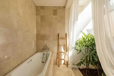 a bath tub with a ladder sitting next to a window at 2 Bedroom private Pool Seminyak in Seminyak