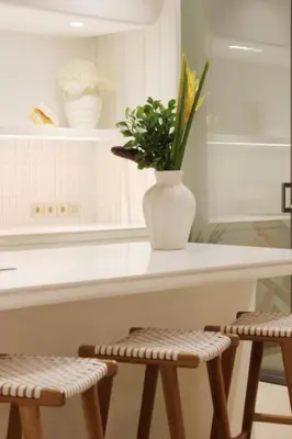a vase of flowers sitting on a counter with two stools at Jipsi Villas Canggu in Canggu