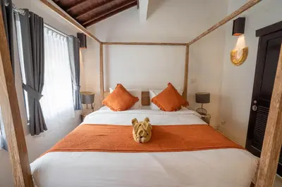 a dog sitting on a bed in a bedroom at Villa Coconut Heaven by Bali Villa Solutions in Seminyak