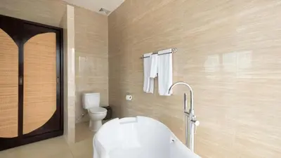 a bathroom with a white tub and a toilet at Villa Latima by Villa Finder in Seminyak