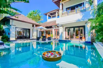 a villa with a swimming pool in front of a house at Chetana 2 BR Private Pool Villa in Ujung