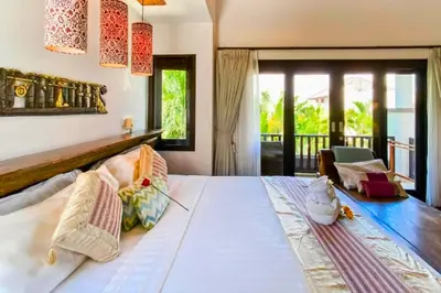 a bedroom with a large white bed and a balcony at Chetana 2 BR Private Pool Villa in Ujung