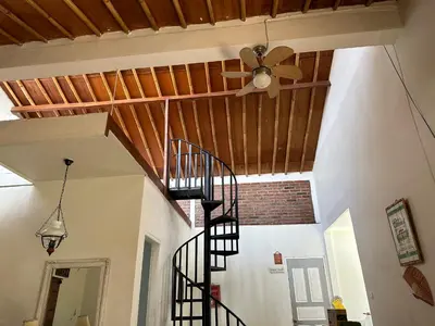 a staircase in a room with a ceiling fan at Cottage House Jimbaran in Jimbaran