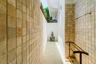 a hallway with a staircase in a building with tiles at Charvi 1 BR Private Pool Villa in Ujung
