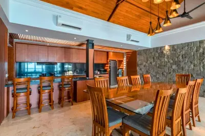 a kitchen with a long wooden table and chairs at Chayanika 4 BR Private Pool Villa With Sea View in Ujung