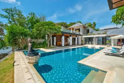 a swimming pool in front of a house at Chayanika 4 BR Private Pool Villa With Sea View in Ujung