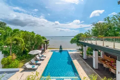 a swimming pool next to the water at a resort at Chayanika 4 BR Private Pool Villa With Sea View in Ujung