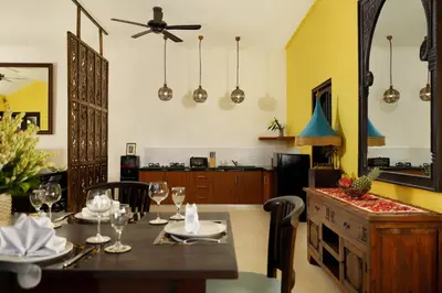 a dining room with a table and a kitchen at Shanti Estate Seminyak by Nakula in Seminyak