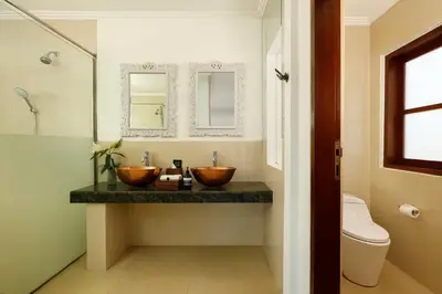 a bathroom with two wooden bowls on a counter at Shanti Estate Seminyak by Nakula in Seminyak
