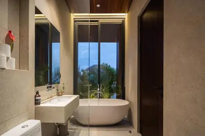 a bathroom with a tub and a sink and a window at ALENY Vila by VoLa in Seminyak