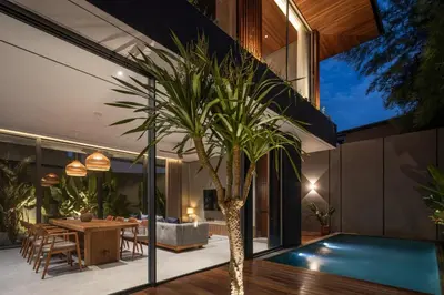 a house with a palm tree in the middle of a pool at ALENY Vila by VoLa in Seminyak