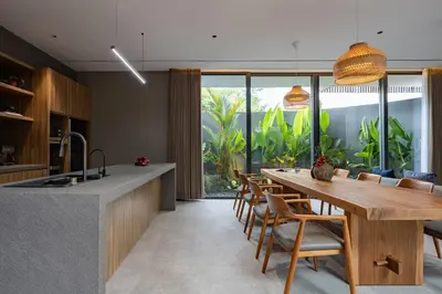 a kitchen and dining room with a wooden table and chairs at ALENY Vila by VoLa in Seminyak