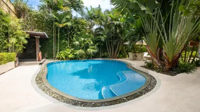 a swimming pool in the middle of a yard at Villa Celeste by Villa Finder in Seminyak