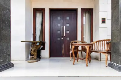 a pair of chairs and a table in front of a door at SN Guest House Near Trans Studio Mall in Legian